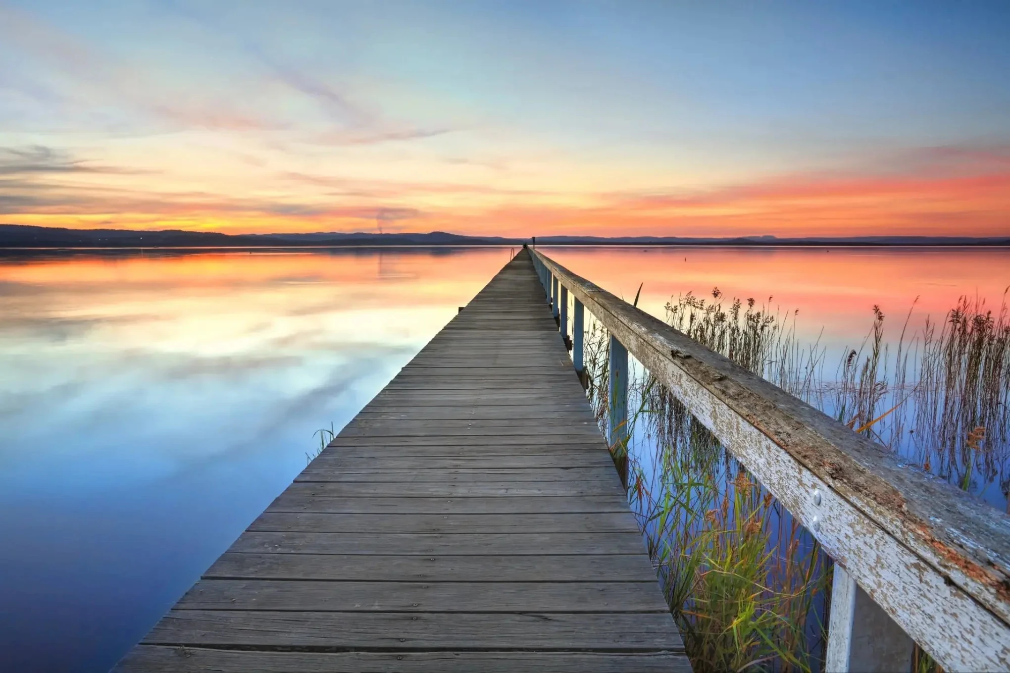 Calm Tuggerah jetty at sunset with still water – symbolising clarity and support on the Central Coast